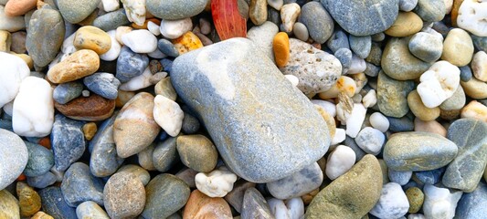 High-resolution texture of natural river gravel. Smooth, mixed pebbles filling the frame completely, ready for commercial background use and digital photo manipulation
