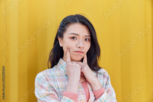 Εκτύπωση καμβά Playful young woman pouting against yellow wall