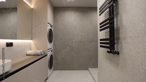 Compact Laundry With Storage. Minimalist Bathroom Featuring Builtin Storage And Heated Walls