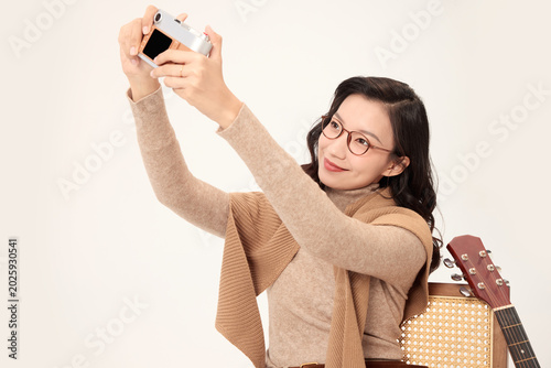 Canvas-taulu Smiling woman taking selfie with compact camera
