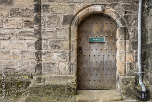 Detail of a weathered sandstone wall with a door.