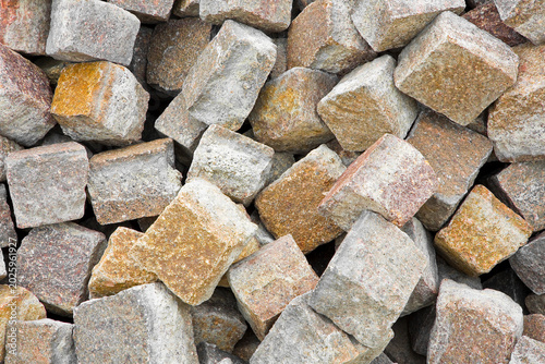 PORPHYRY STONE CUBES FOR PAVING AND LANDSCAPING IN A CONSTRUCTION SITE - Natural cobblestone blocks with rough surface, perfect for construction, flooring, outdoor design, and architectural background