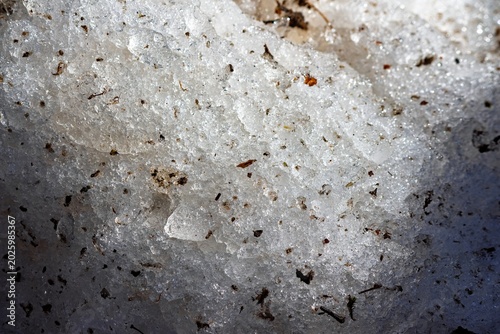 Foto Gritty, thawing roadside snow glistens under bright spring sun