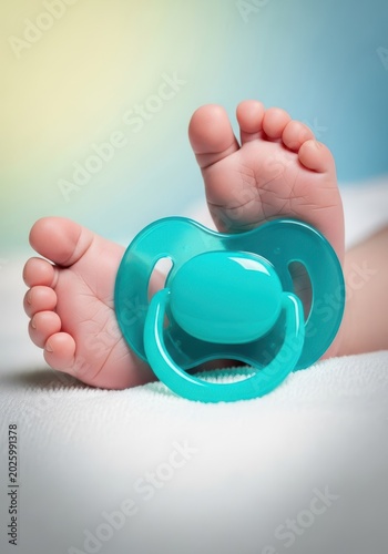 Tiny little feet near a comforting plastic soother, symbolizing the pure innocence and new beginning of the early stages of life, blanket, simple, studio