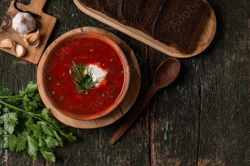 Traditional Ukrainian borscht soup with sour cream and spoon top view