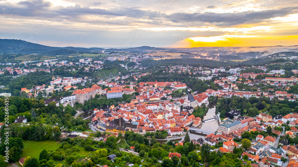 Fototapeta premium At sunrise, Cesky Krumlov awakens as soft light illuminates its colorful rooftops and the Vltava River.