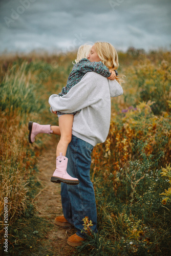 Happy sisters hugging outdoors before a storm – candid family lifestyle portrait