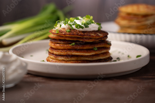 Tableau sur toile close-up of a warm stack of golden-brown savory pancakes on a white ceramic plat
