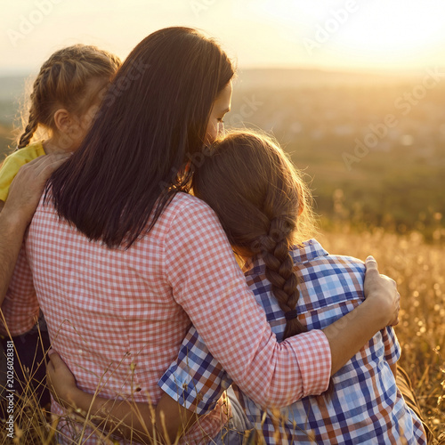 Warm emotional family connection in scenic rural landscape during peaceful sunset evening outdoors