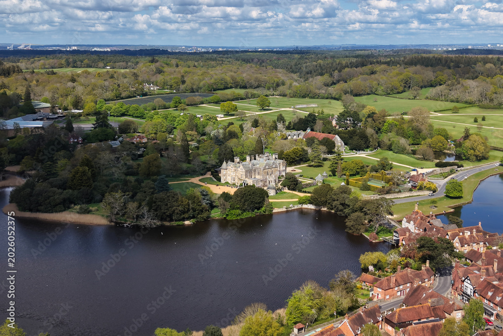 Fototapeta premium Aerial drone footage of Beaulieu village in Hampshire, England, showcasing a historic rural settlement surrounded by the New Forest countryside