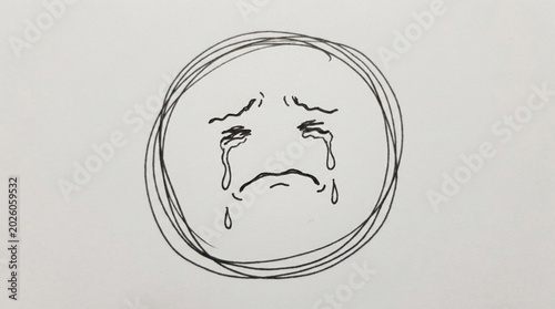 Foto Sad face drawing with tears crying inside a circle.