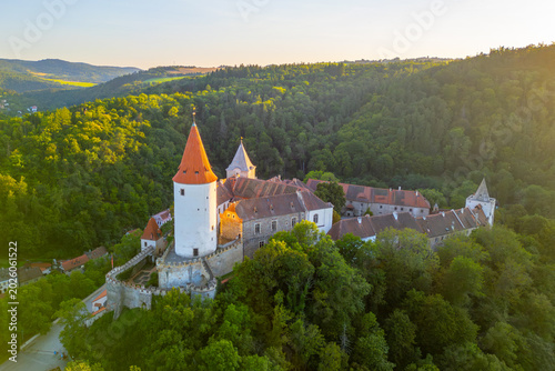 Photos Krivoklat Castle is beautifully illuminated during sunset, surrounded by green forests