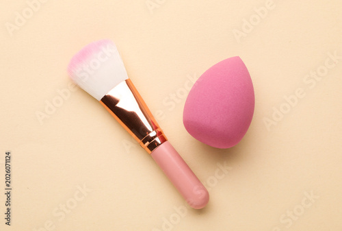 Bild auf Leinwand Pink makeup sponge and brush on beige background, top view