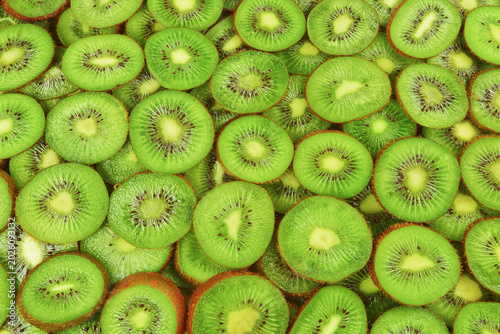 Top view of heap of sliced kiwi as textured background.