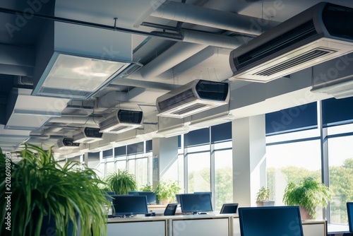 Contemporary open plan office showing hvac units, ventilation ducts, and green plants