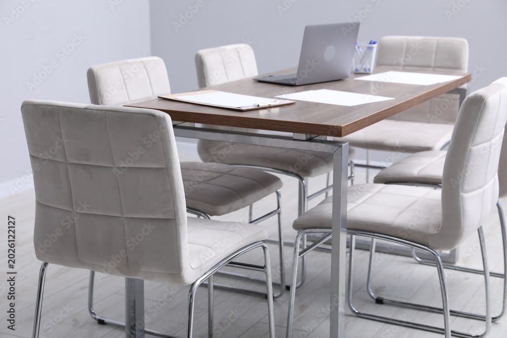 Obraz premium Stylish chairs and wooden table in office