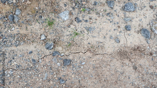 Foto Cracked dry earth and gravel texture