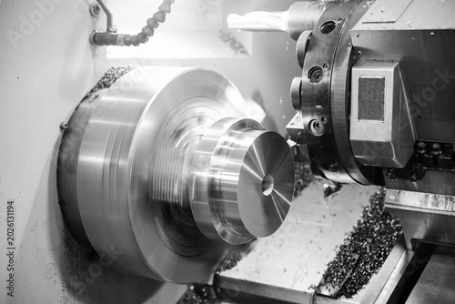 Photos CNC lathe processes metal part.