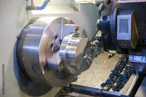 Foto CNC lathe processes metal detail.
