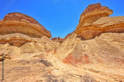 Dramatic desert canyon in the Namibe Desert with layered sandstone formations under a clear blue sky