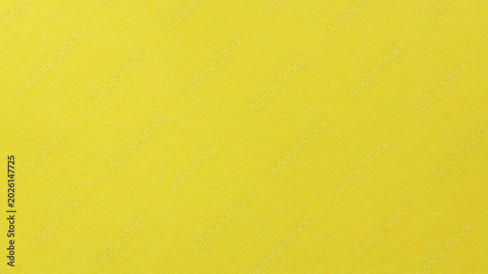 Fototapeta premium Yellow textured paper background with subtle grain for cheerful creative design projects