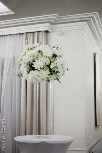 Elegant white floral decoration in a luxury restaurant interior. Sophisticated flower arrangement creating an exclusive and upscale atmosphere, perfect for themes related to fine dining, weddings, eve