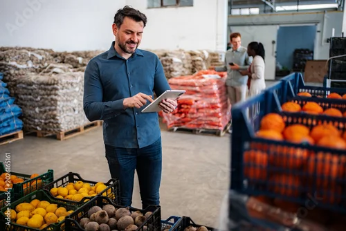 Obraz Man using tablet checking inventory in food warehouse