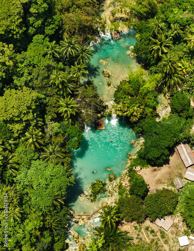 Cambugahay Falls is a stunning, three-tiered waterfall located in the town of Lazi on Siquijor Island, the Philippines. Renowned for its vibrant, milky-turquoise waters and lush jungle setting