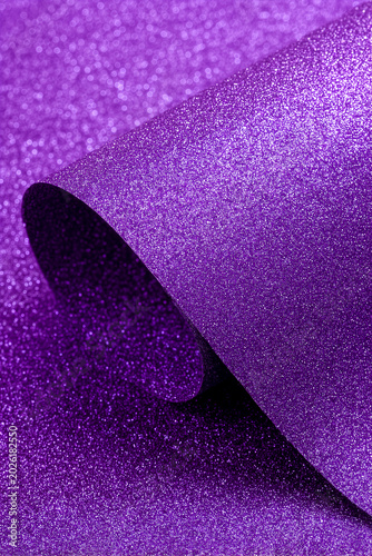 Elegant purple glitter paper mockup with a smooth curved roll layer, featuring a vibrant shimmering texture ideal for luxury holiday and craft designs