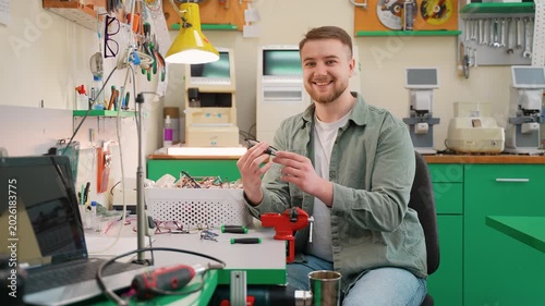 Smiling optician repairing eyeglasses in workshop