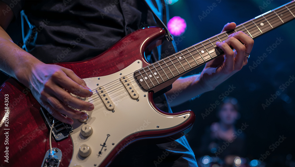 Obraz premium 楽器の質感を際立たせた日本人ギタープレーヤーの演奏接写