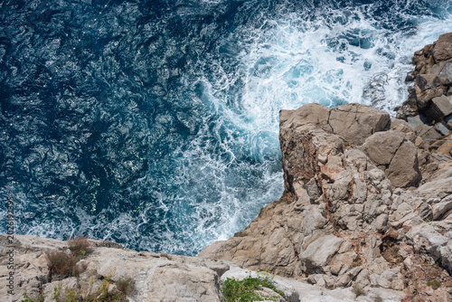 Top view of cliffs and deep blue Adriatic Sea near Dubrovnik, Croatia, in sunny summer day