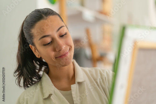 Fotografía Young woman artist concentrating on painting in studio
