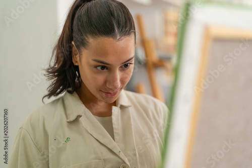 Obraz na plátně Young woman artist concentrating on painting process