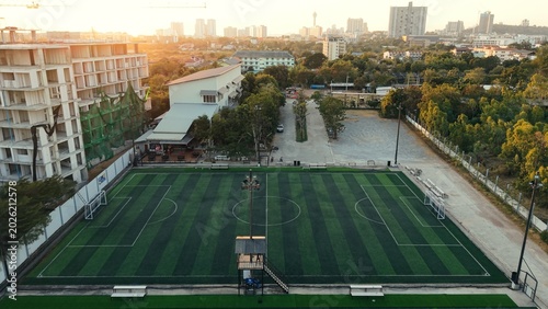 Photography Artificial turf football field in pattaya city with sunset light over constructi