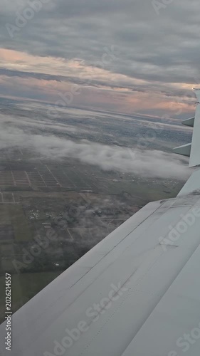 Vertical video of an airplane wing at dawn during a flight to Buenos Aires. Landing in Argentina.
