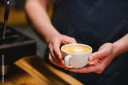 Photography Barista serving coffee latte with heart art