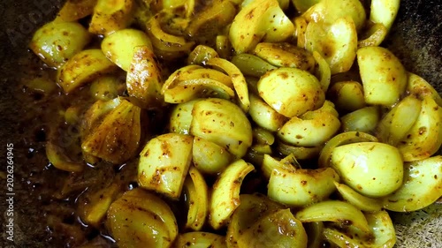 Frying chopped onion with masala powder in pan, indoor Chiangmai Thailand.