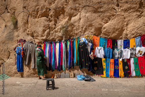 Selling bright multi-colored traditional dresses inside Todra Gorge, Morocco.