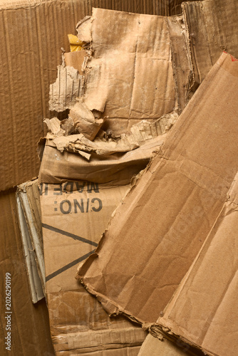 crushed brown corrugated cardboard boxes pile, torn wrinkled paperboard surfaces, full frame texture view, recycling environmental waste management