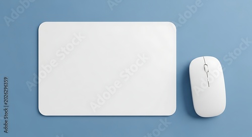 Blank white rectangular mouse pad with modern wireless computer mouse on blue background, workspace mockup template