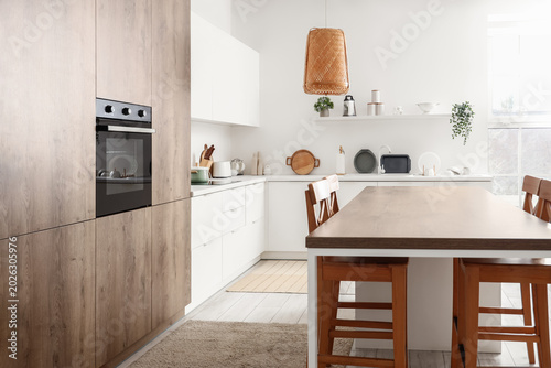 Tableau sur toile Interior of modern kitchen with built-in oven, counters and table