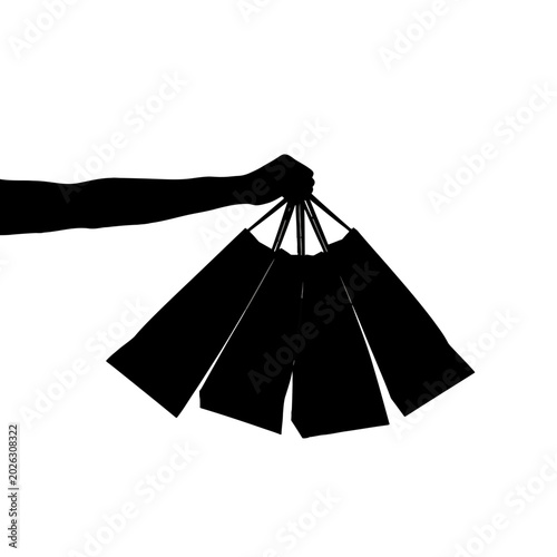 Silhouette of a hand holding multiple shopping bags against a white backdrop.