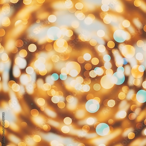 Soft, swirling golden and teal bokeh lights create a dreamy, abstract background effect