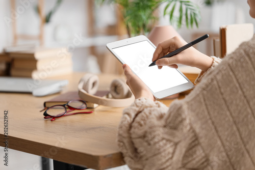 Young woman with stylus usi...