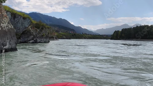 A motorboat ride along mountain river. Slow motion of speedboating on Altai river Katun. Mount Camel is in the background.