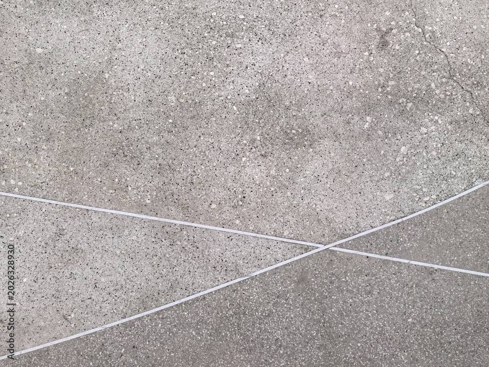Fototapeta premium Abstract pattern of intersecting white lines on a textured concrete surface