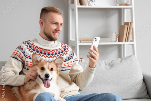 Young man with cute Corgi d...