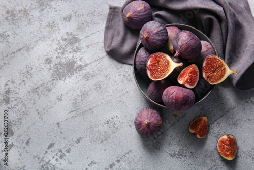 Foto Bowl with fresh ripe figs on grey background