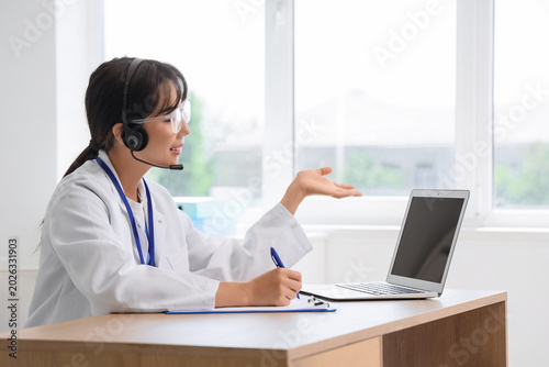 Female Asian doctor with la...